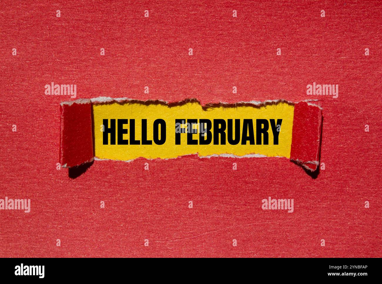 Bonjour février message écrit sur papier rouge déchiré déchiré avec fond jaune. Symbole conceptuel bonjour février. Copier l'espace. Banque D'Images