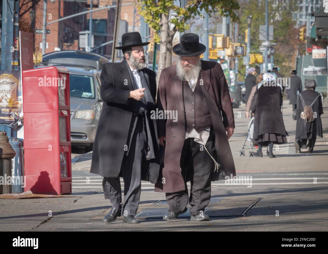 2 hommes juifs orthodoxes, peut-être de la famille, s'engagent dans une conversation animée. Sur Lee Avenue à Williamsburg, Brooklyn, New York. Banque D'Images