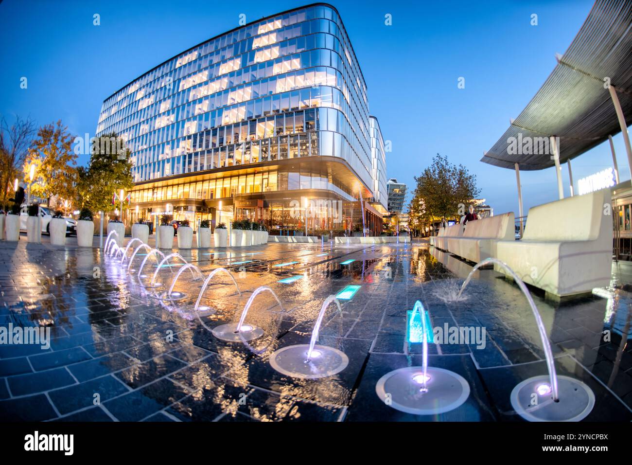 The Wharf Interactive Fountains Washington DC // WASHINGTON DC — des fontaines interactives et des plans d'eau animent les espaces plaza du Wharf, un quartier riverain réaménagé dans le sud-ouest DC, alors que le crépuscule s'installe sur le développement à usage mixte. Les bâtiments modernes encadrent les expositions aquatiques, qui offrent à la fois un attrait esthétique et des espaces de rassemblement publics. Banque D'Images