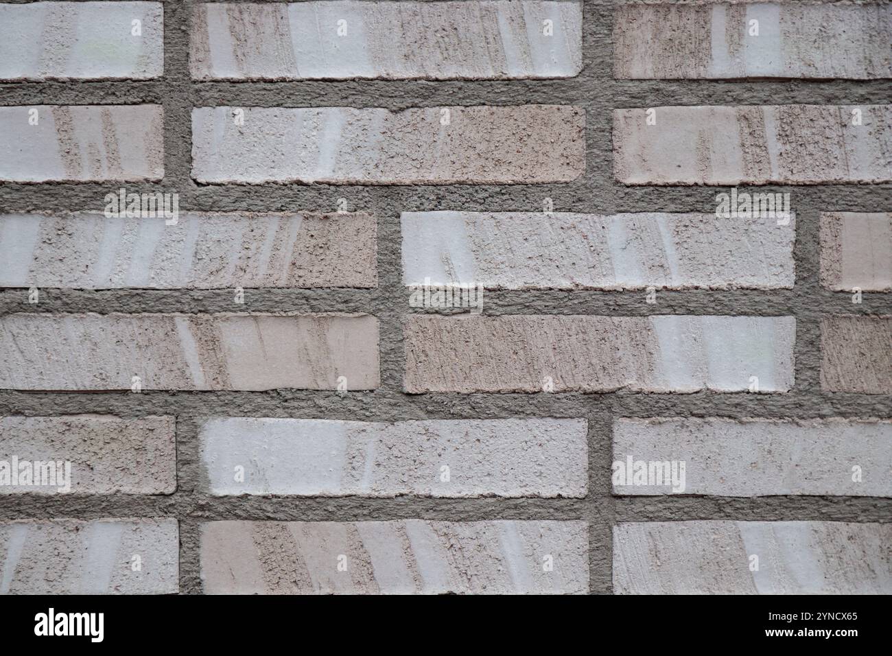 Fond de mur de briques beige et gris en gros plan. Fond de bloc de tuile de pierre grise avec texture horizontale de brique grise. Surface de briques grises Banque D'Images