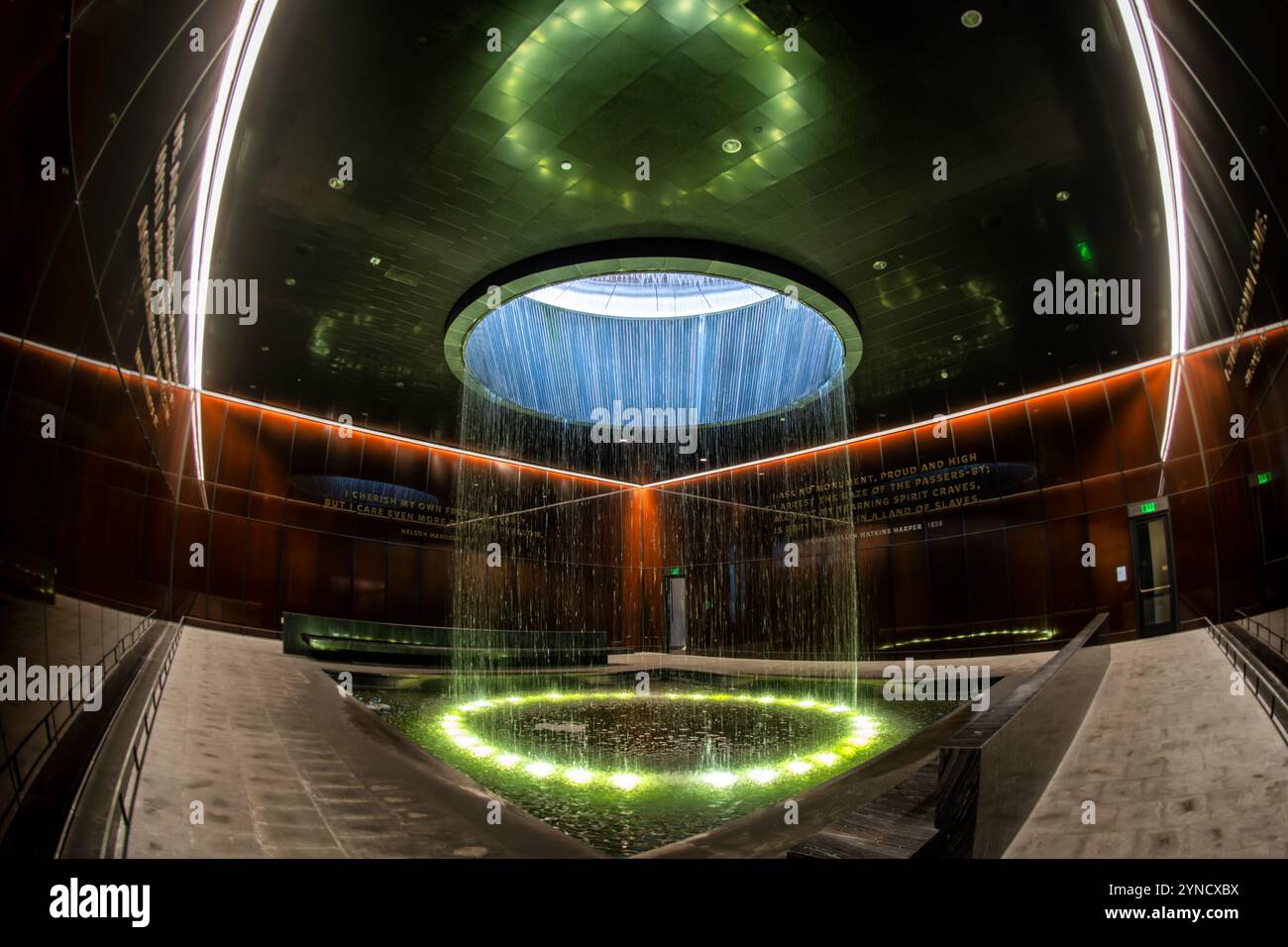 Musée national d'histoire afro-américaine contemplative court Washington DC // WASHINGTON DC — la cour contemplative du musée national d'histoire et de culture afro-américaine présente une fontaine cylindrique tombant d'une lucarne dans une piscine centrale. Conçu par l'architecte Phil Freelon, l'espace comprend des murs en verre Bendheim en bronze caramel avec des noyaux de mailles lumineux. Cet espace de méditation offre aux visiteurs un lieu de réflexion après avoir vu les expositions du musée. Banque D'Images