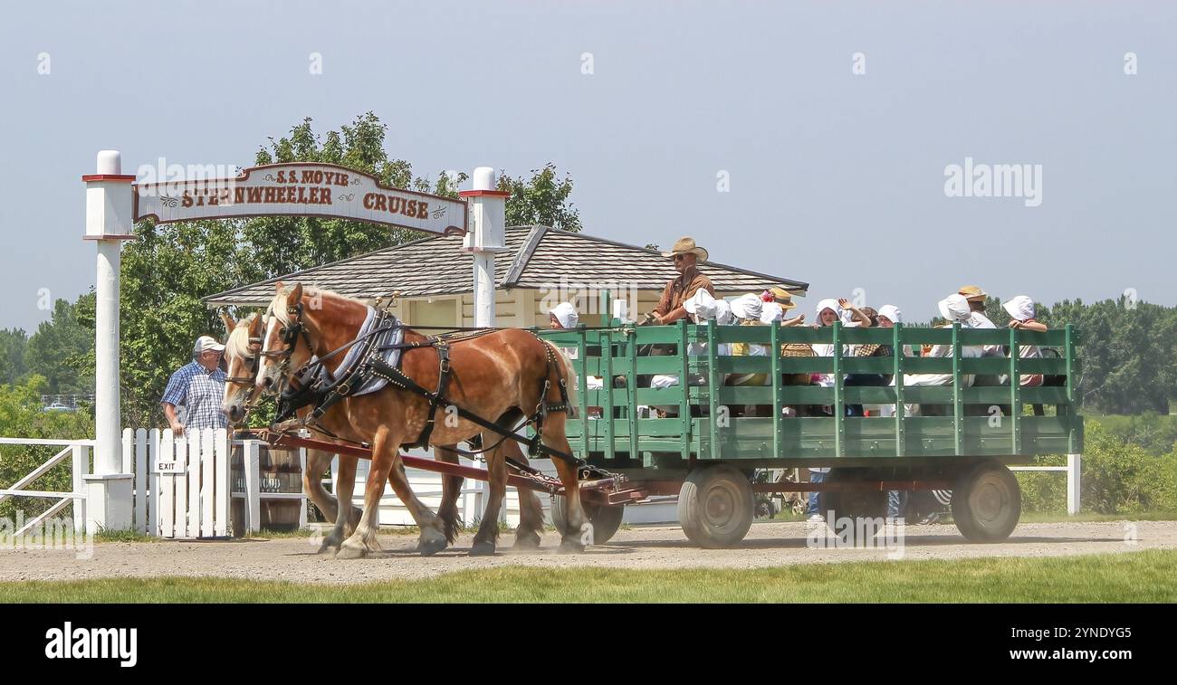 Calgary, Alberta, Canada. 10 juin 2023. Quelqu'un profitant d'une journée d'été au Heritage Park, conduisant un chariot tiré par un couple de chevaux et portant du peop Banque D'Images