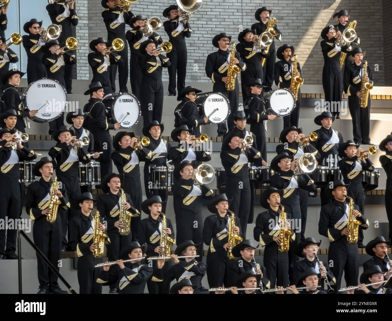 Calgary, Alberta, Canada. 12 juillet 2024. Une fanfare, vêtue d'uniformes noirs et blancs et de chapeaux de cow-boy, se produit énergiquement sur des stands étagés. Mu Banque D'Images