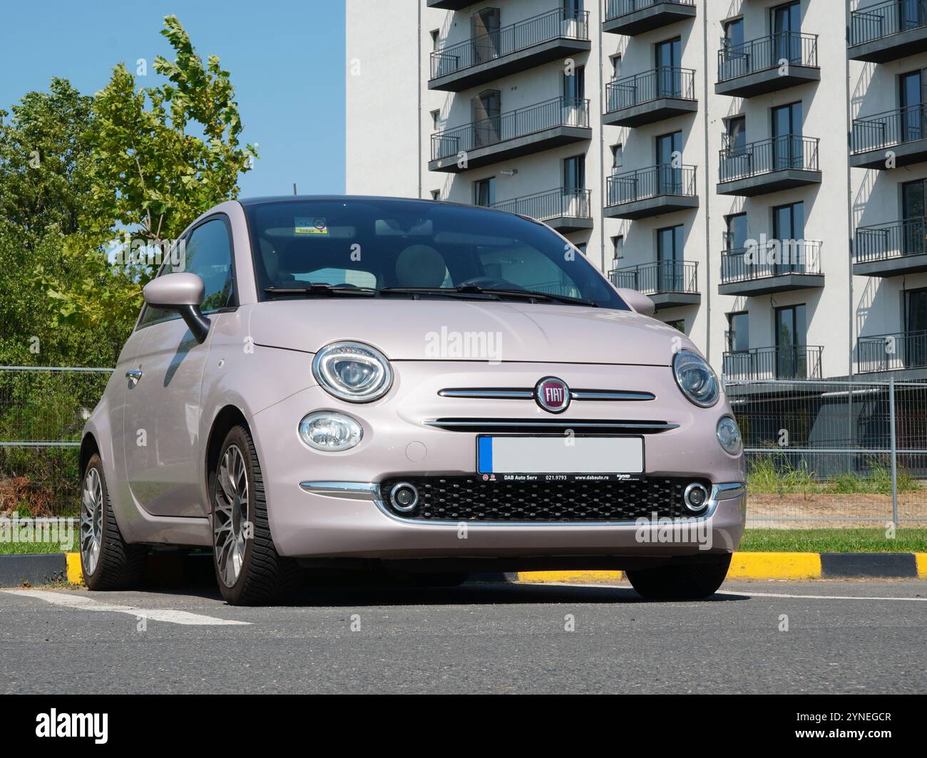 Bucarest, Roumanie – 14 août 2024 : gros plan de la voiture rose Fiat 500 sur le parking à côté de l'immeuble d'appartements Banque D'Images