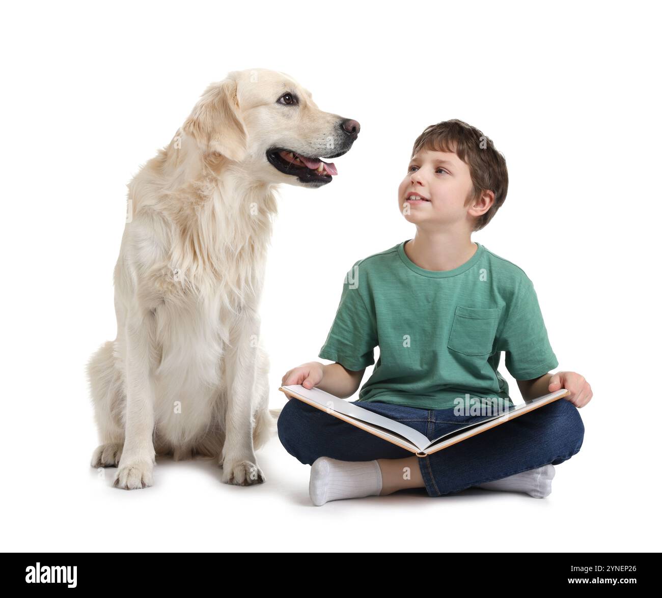 Garçon lisant le livre avec son chien mignon sur fond blanc Banque D'Images