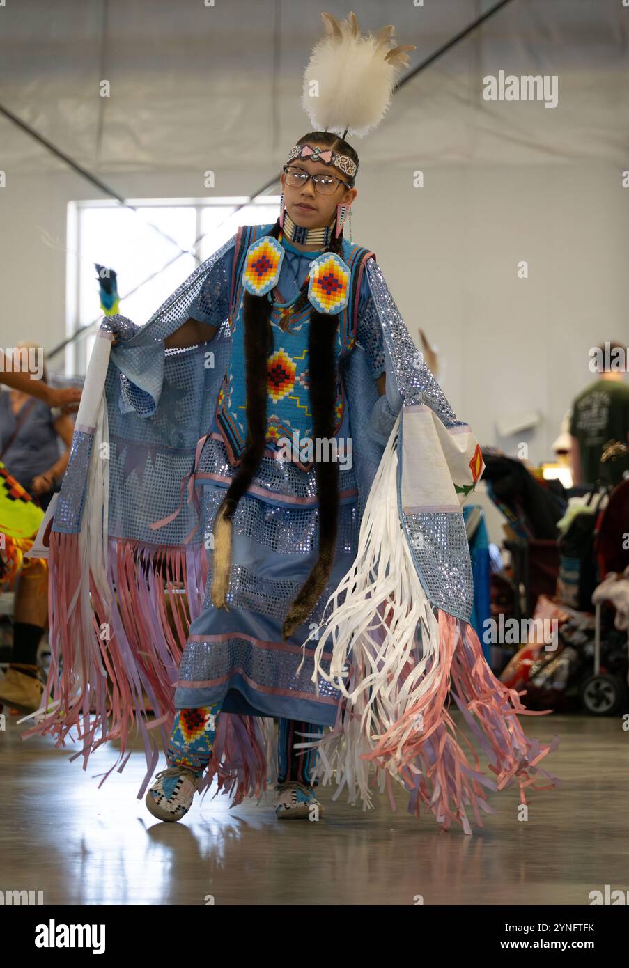 Jeune femme amérindienne portant un costume de châle fantaisie lavande et rose dansant dans un pow wow à Helena, Montana. Banque D'Images