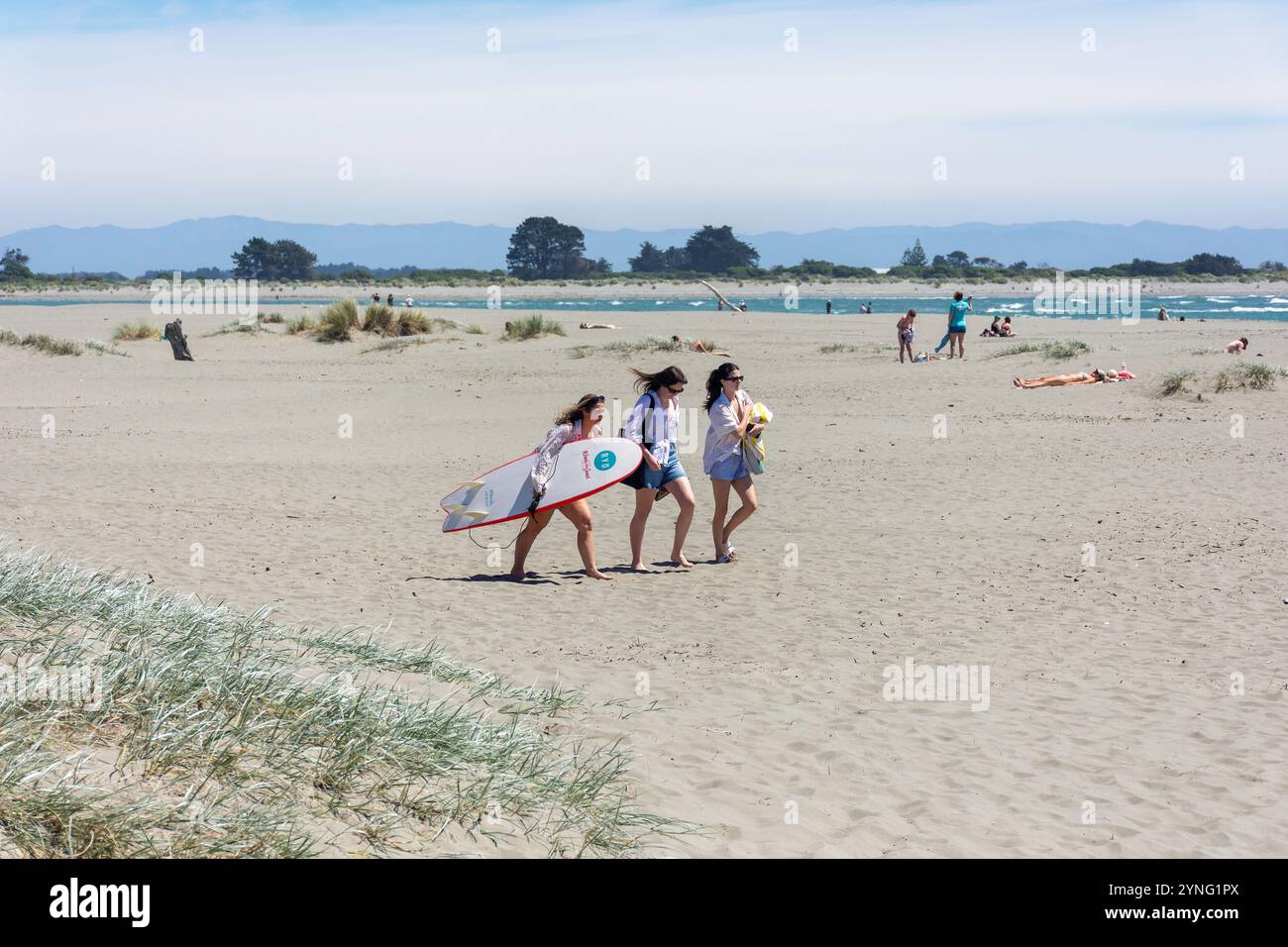 Jeunes femmes avec planche de surf, Sumner Beach, Sumner, Christchurch (Ōtautahi), Canterbury Region, nouvelle-Zélande Banque D'Images