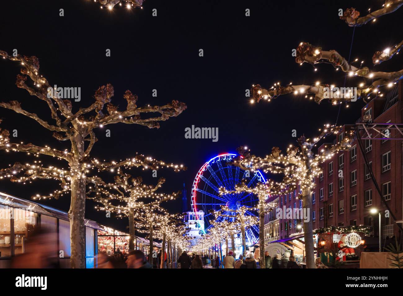 Paysage de nuit sur la promenade et la passerelle le long de la rivière Rhin et étal de marché avec fond de grande roue du marché de Noël, Weihnachts Banque D'Images