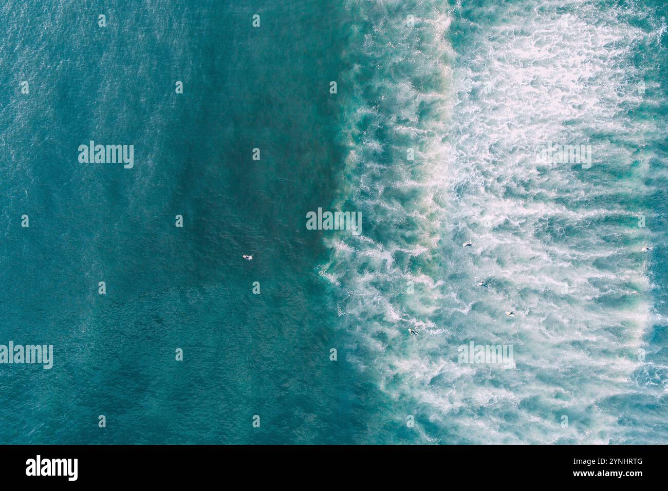 vue d'une vague sur le rivage d'une plage au lever du soleil, et les gens surfent. Photographie aérienne de dessus avec un drone. Banque D'Images