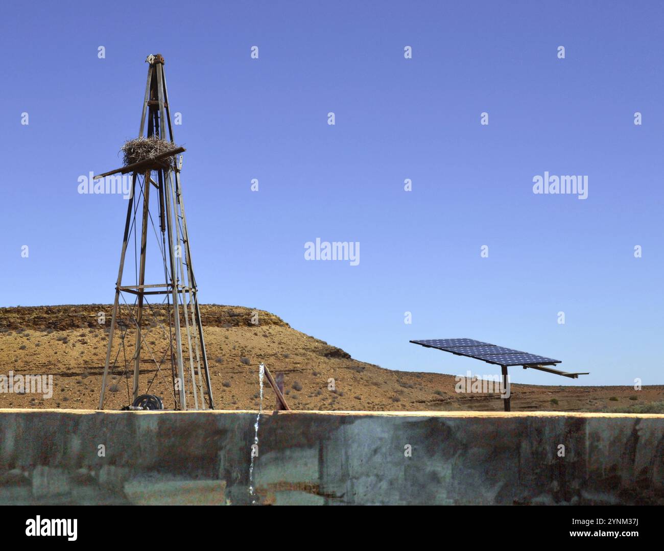 Ancien moulin à vent et nouvelle pompe à eau solaire au barrage de ferme sur la Knersvlakte à Namaqualand, Afrique du Sud. Banque D'Images