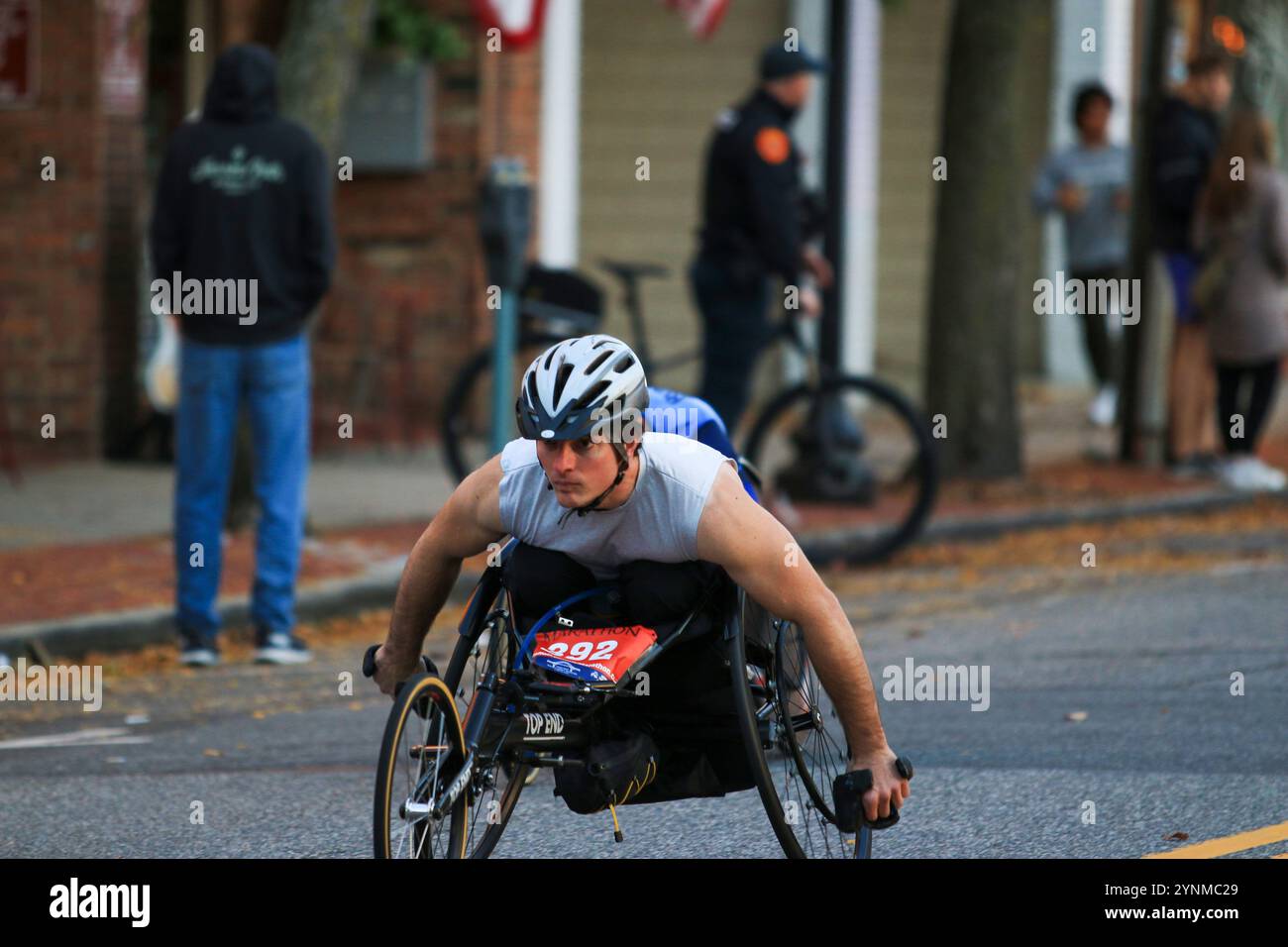 Babylon, New York, États-Unis - 22 octobre 2023 : un coureur en fauteuil roulant déterminé pousse dans une rue bordée de spectateurs lors d'un événement local à l'automne. Banque D'Images