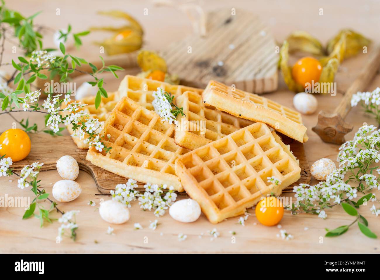Gaufres avec sucre en poudre, fleurs de printemps et physalis – composition alimentaire rustique Banque D'Images