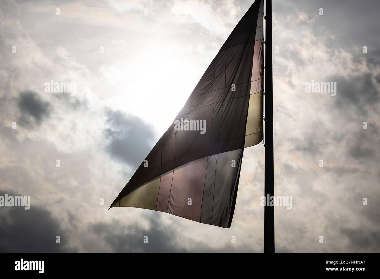 Berlin, Allemagne. 26 novembre 2024. Un drapeau allemand est illuminé par le soleil dans le ciel nuageux. Crédit : Hannes P. Albert/dpa/Alamy Live News Banque D'Images