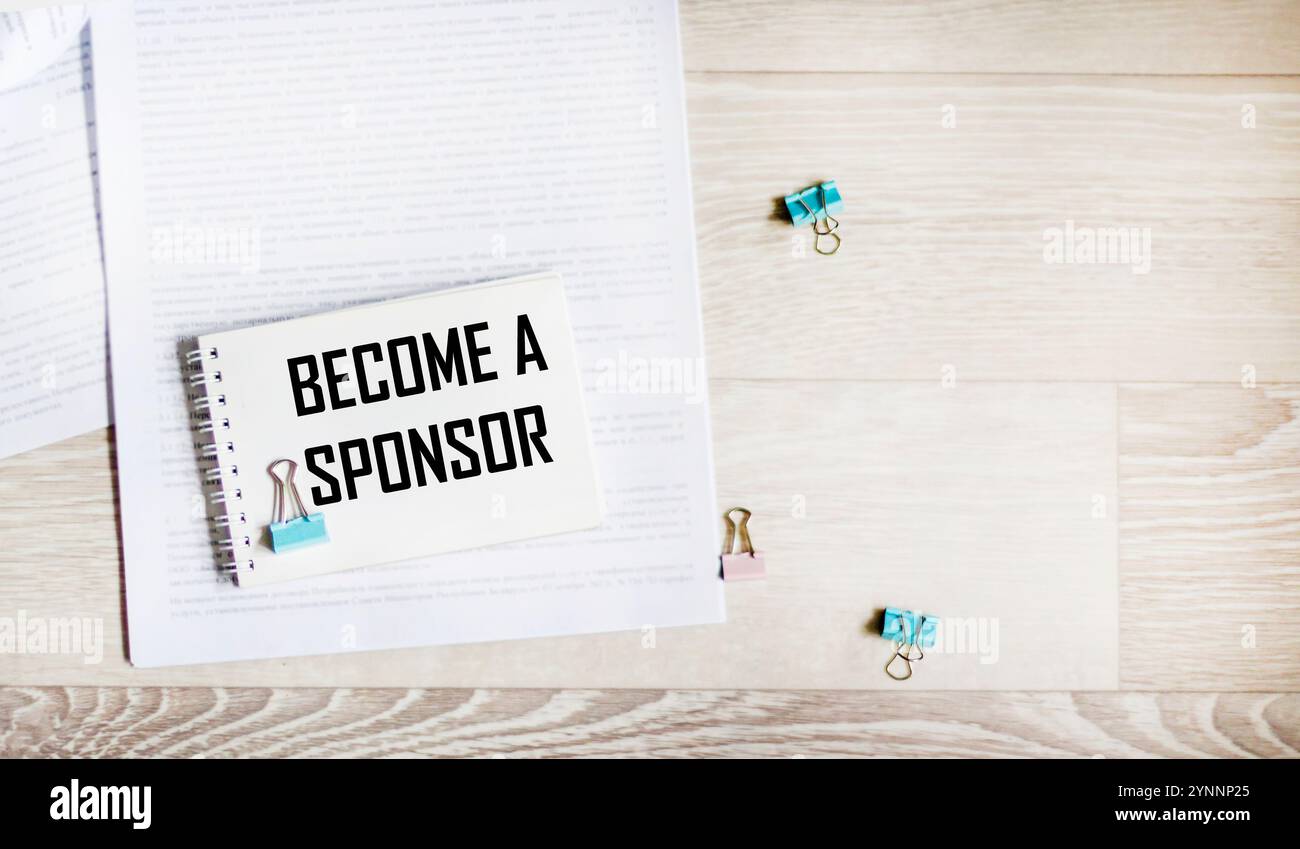 DEVENEZ SPONSOR le texte est écrit sur une feuille blanche de bloc-notes, sur des documents Banque D'Images