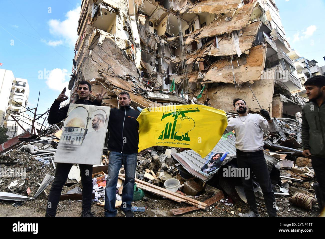 Beyrouth, Liban. 26 novembre 2024. Hommes cary drapeau du Hezbollah sur des bâtiments détruits sur le site d'une frappe aérienne israélienne de nuit qui a ciblé la zone de Tayouneh à la périphérie de la banlieue sud de Beyrouth, libanaise, mardi 26 novembre 2024. De vastes frappes aériennes israéliennes ont frappé Beyrouth, sa banlieue et d'autres régions du Liban en prévision d'un cessez-le-feu attendu pour mettre fin à la guerre entre le Hezbollah et Israël. Photo de Rahim Rhea/UPI. Crédit : UPI/Alamy Live News Banque D'Images
