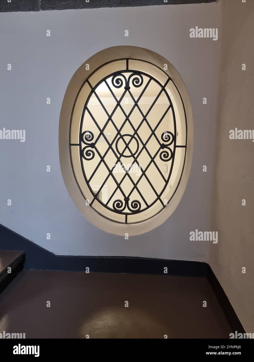 Fenêtre ovale ornée décorée d'un motif de cadre métallique à l'intérieur d'un bâtiment à Berlin, en Allemagne Banque D'Images Fenêtre ovale ornée décorée d'un motif de cadre métallique à l'intérieur d'un bâtiment à Berlin, en Allemagne Banque D'Images