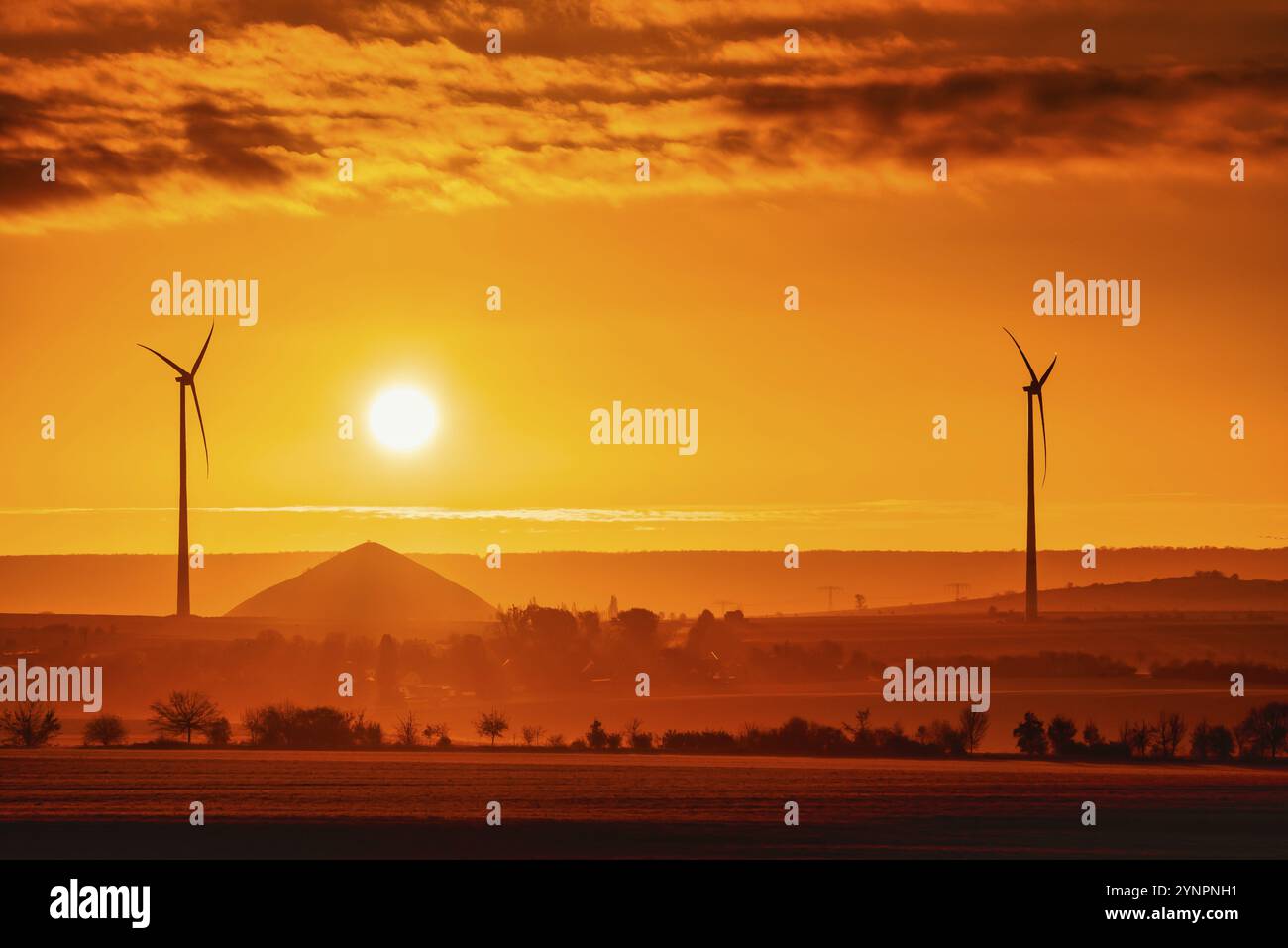 Lever du soleil avec vue sur les éoliennes et les tas miniers des mines de cuivre dans le sud des monts Harz Banque D'Images