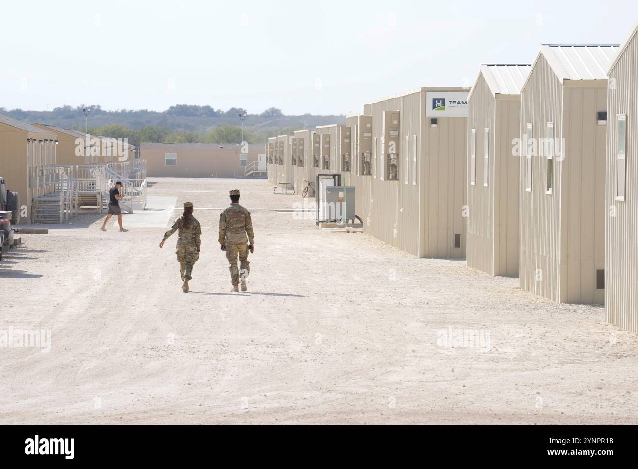 Eagle Pass, États-Unis. 26 novembre 2024. Un soldat de la Garde nationale du Texas passe devant des dizaines d'unités de logement à la base opérationnelle avancée pour l'opération Lone Star lors de la visite du nouveau « tsar de la frontière » Tom Homan (non représenté) et d'autres forces de l'ordre dans leur salle à manger à l'extérieur d'Eagle Pass, Texas, le 26 novembre 2024. Crédit : Bob Daemmrich/Alamy Live News Banque D'Images