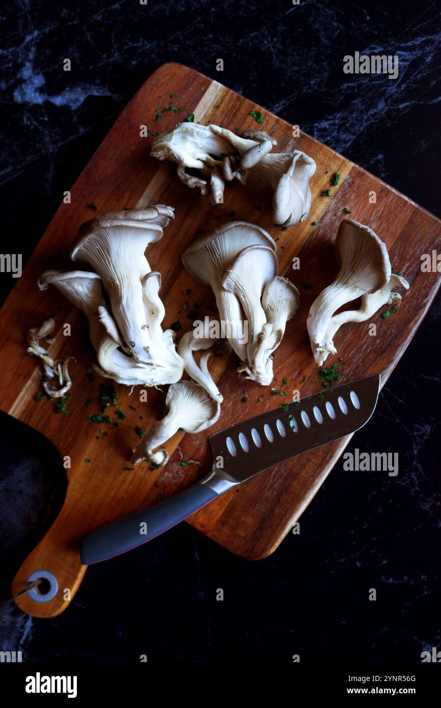 Champignons d'huître frais sur une planche à découper, gros plan. Banque D'Images