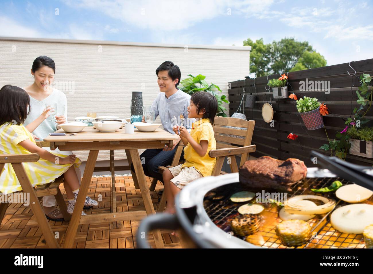 Famille ayant BBQ sur terrasse Banque D'Images