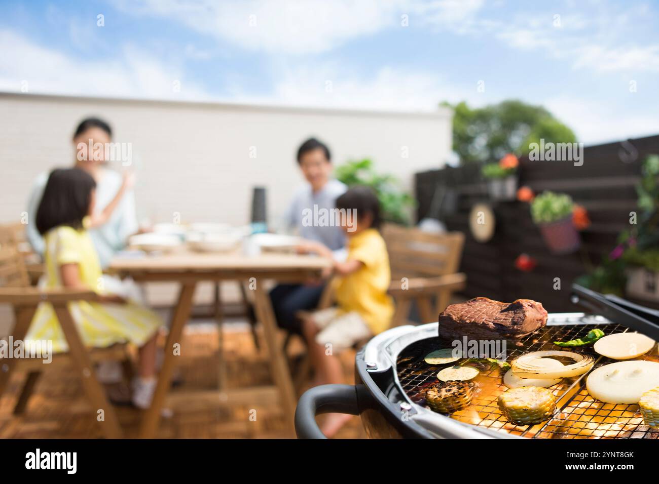 Famille ayant BBQ sur terrasse Banque D'Images