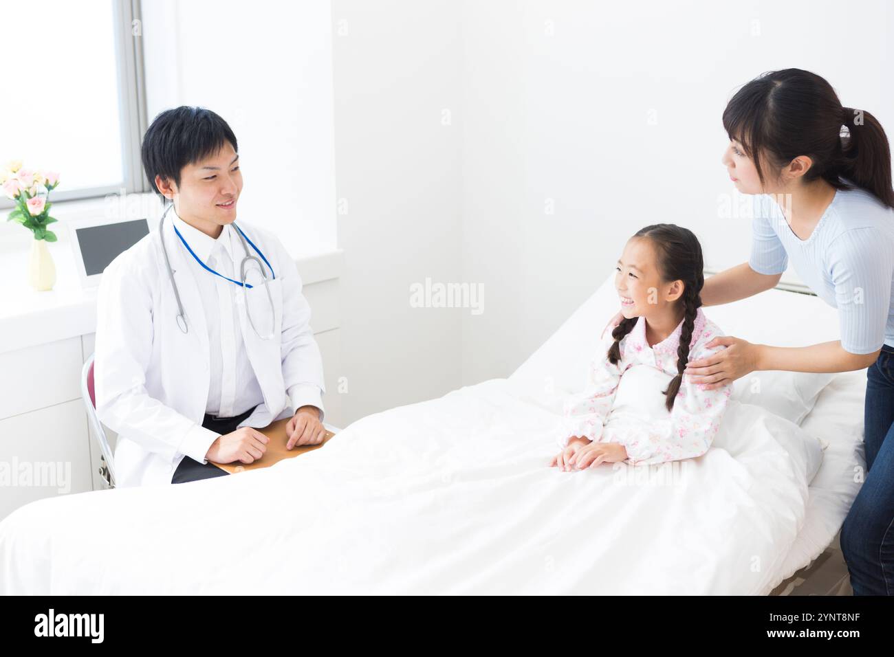 Médecin examinant le patient et la fille assis sur le lit Banque D'Images