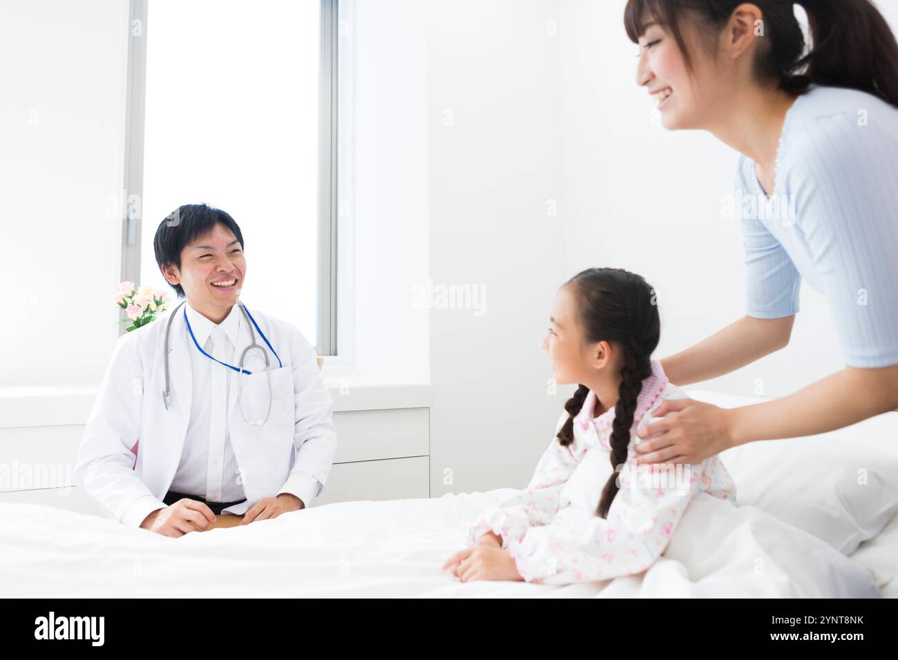 Médecin examinant le patient et la fille assis sur le lit Banque D'Images