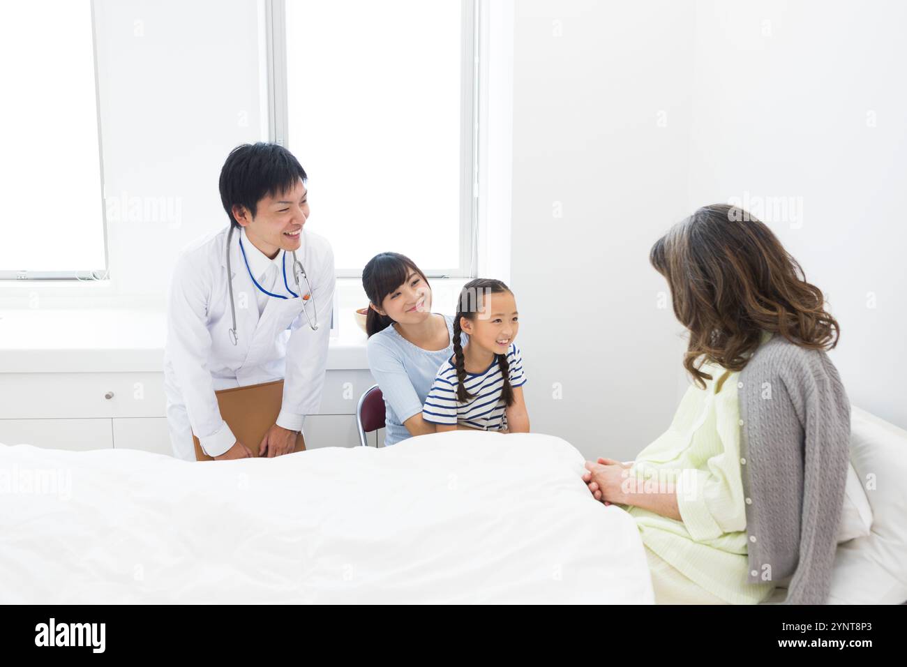 Femme âgée avec des membres de la famille qui sont venus lui rendre visite Banque D'Images
