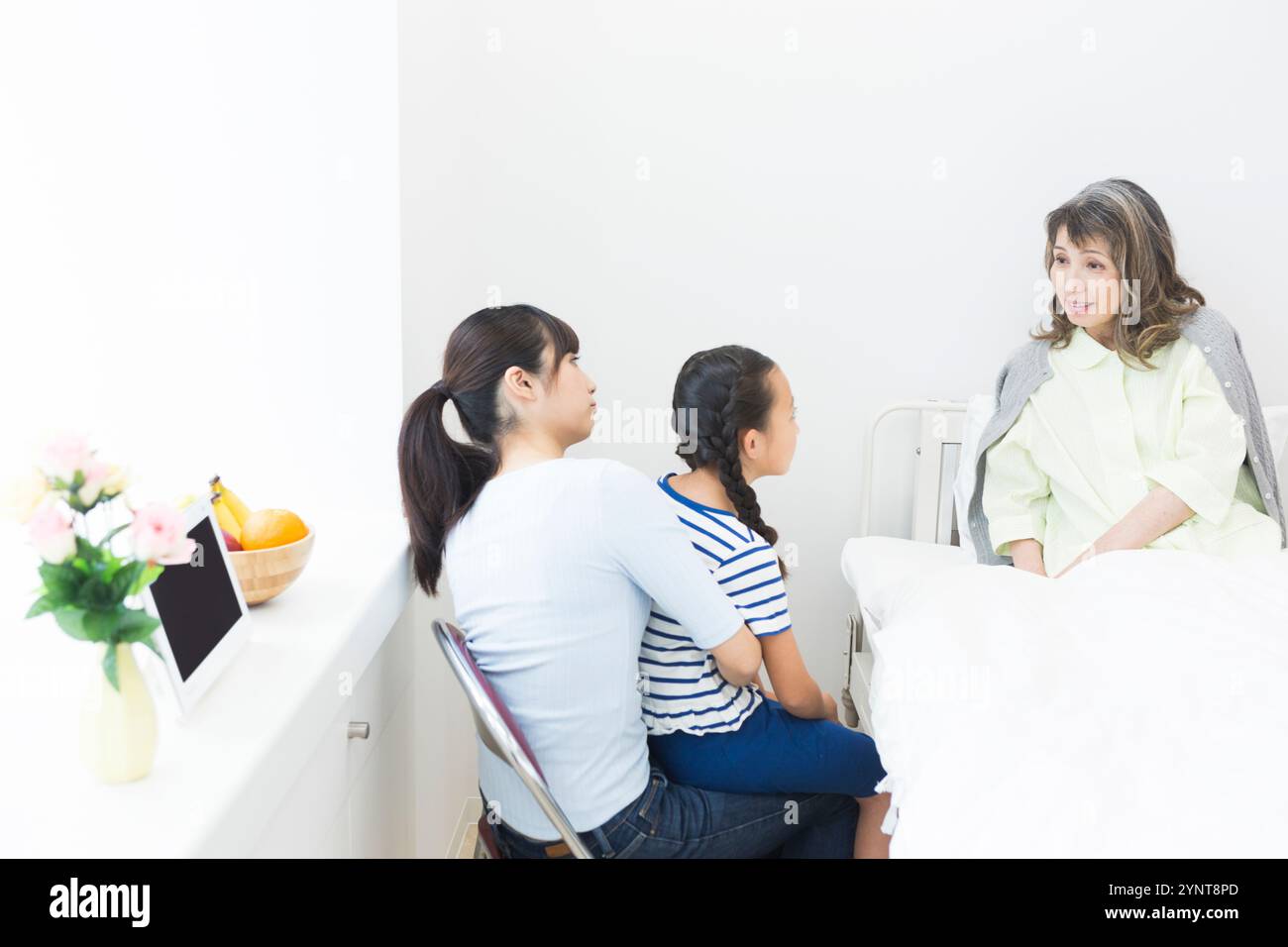 Femme âgée avec des membres de la famille qui sont venus lui rendre visite Banque D'Images