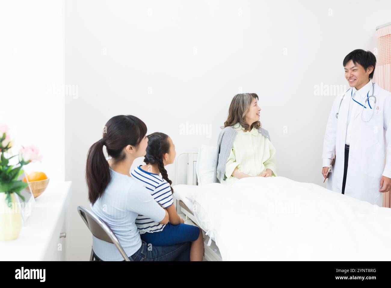Femme âgée avec des membres de la famille qui sont venus lui rendre visite Banque D'Images