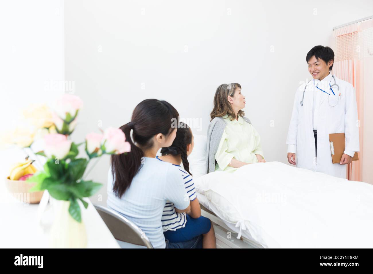 Femme âgée avec des membres de la famille qui sont venus lui rendre visite Banque D'Images