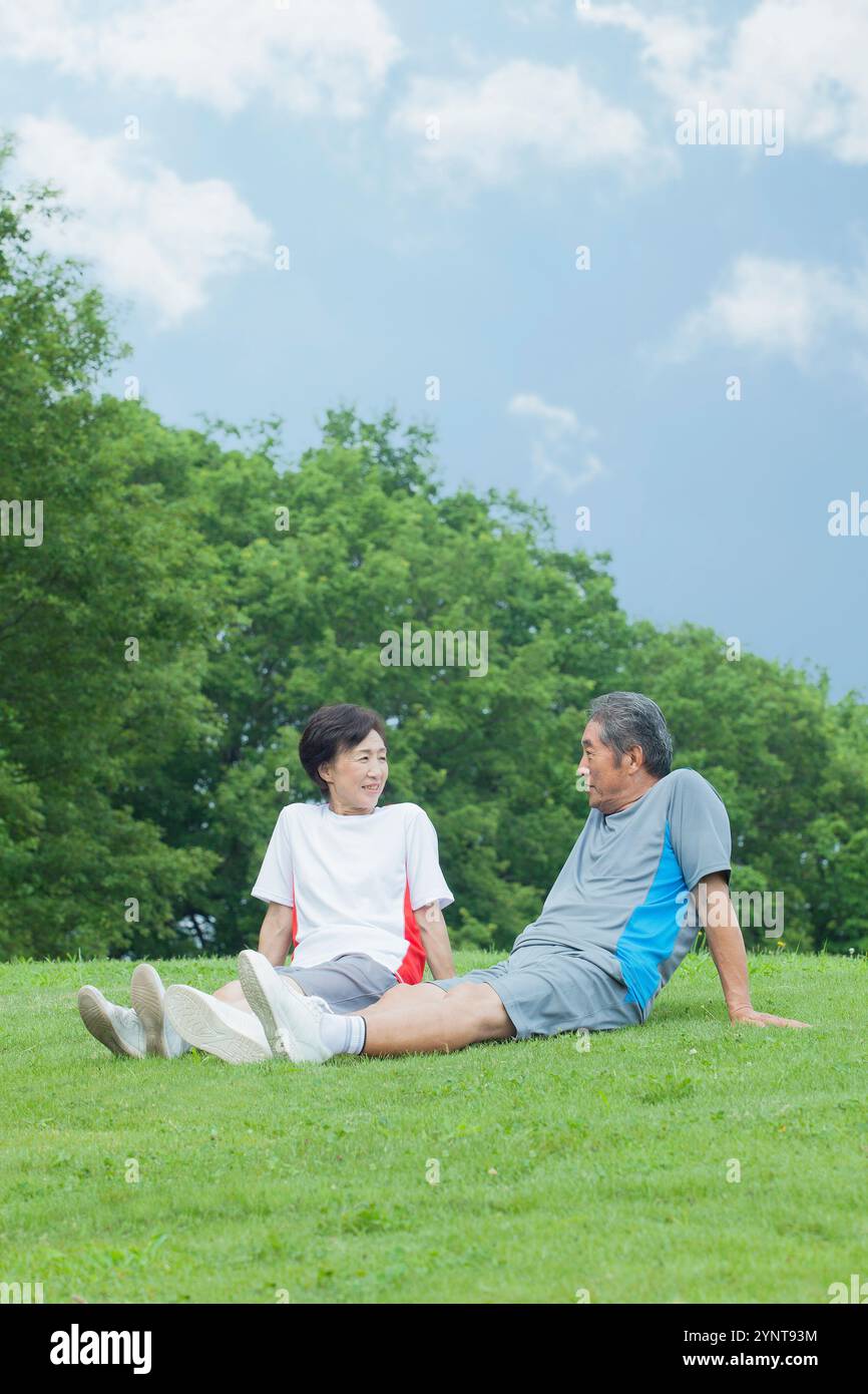 Couple sitting on lawn Banque D'Images