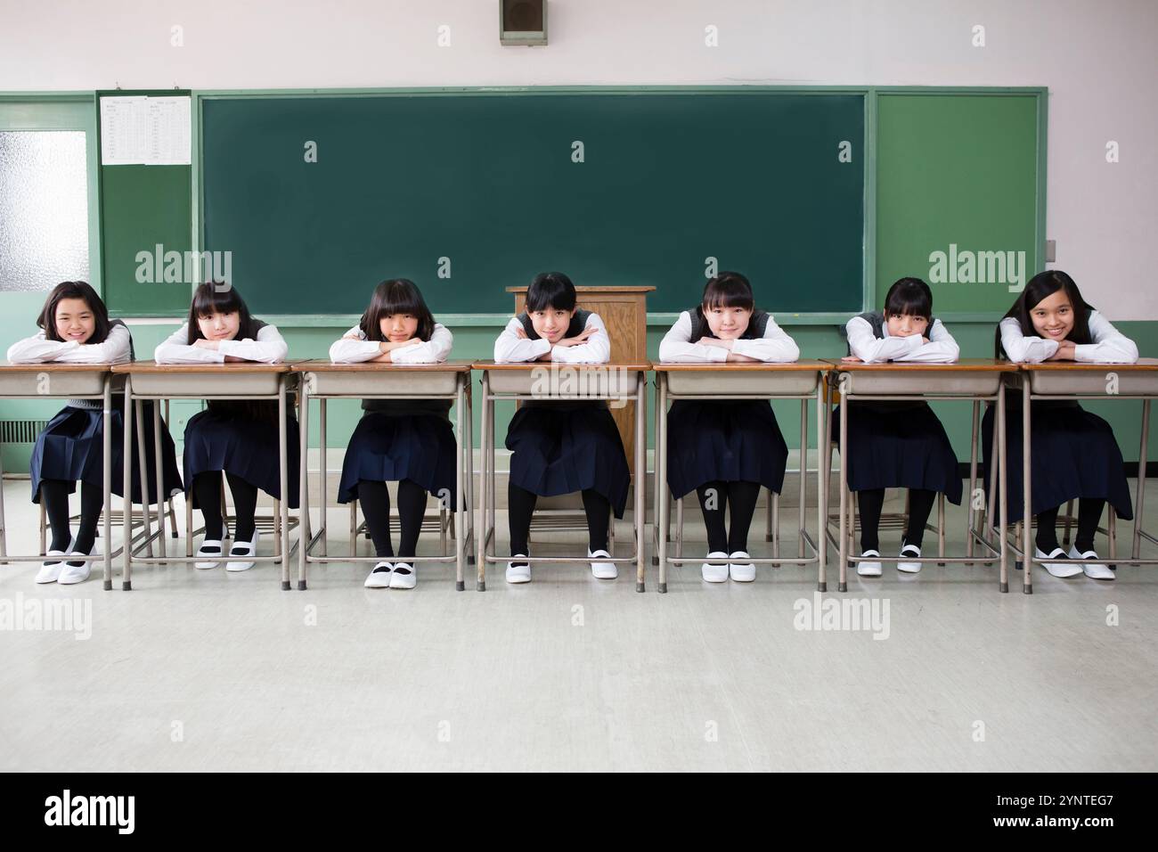 Filles assises dans une rangée de bureaux Banque D'Images