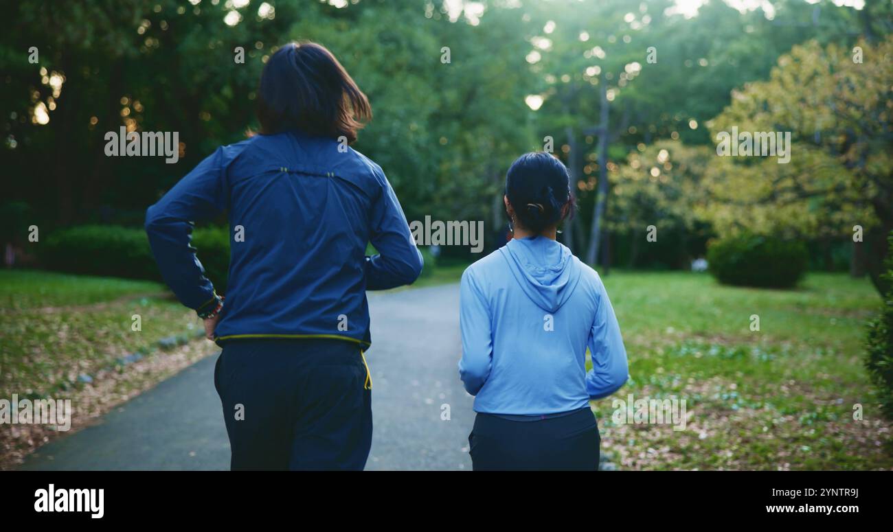 Parc, couple d'amis et courir pour la remise en forme pour les soins personnels, le bien-être et la santé au Japon. Les gens, le dos et le jogging en plein air à la forêt pour Banque D'Images