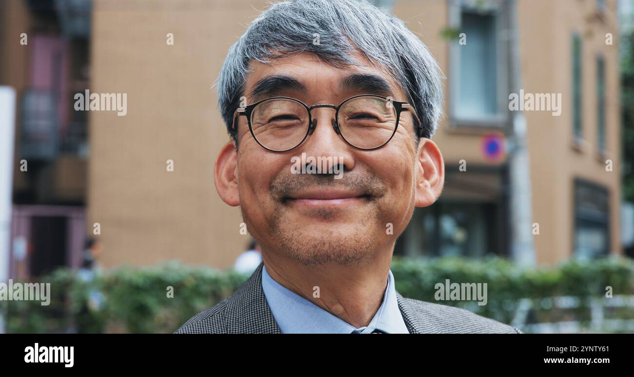 Affaires, ville et portrait de l'homme mature en plein air au Japon pour le trajet matinal ou voyage au travail. A propos de nous, lunettes et sourire avec visage de heureux Banque D'Images