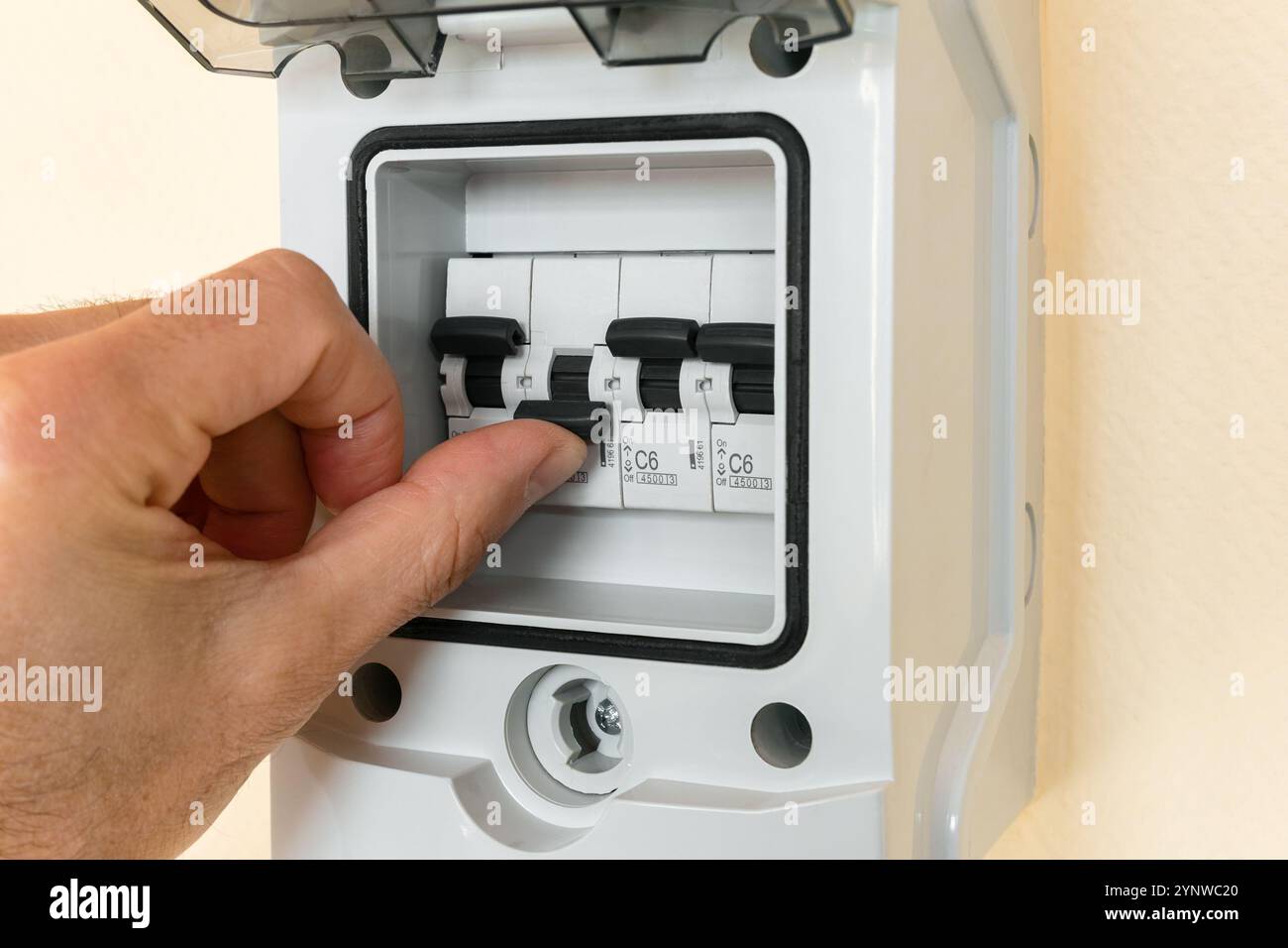 La main d'un homme active un disjoncteur électrique désactivé. Banque D'Images