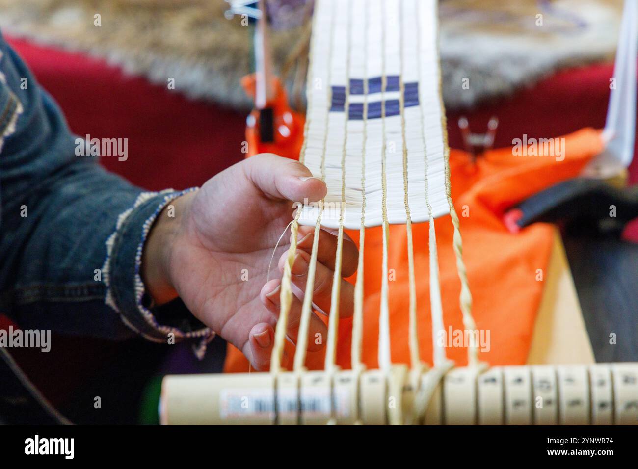 Un artisan indigène créant une ceinture de wampum sur le site historique d'État de Ganondagan à Victor, NYC. Banque D'Images