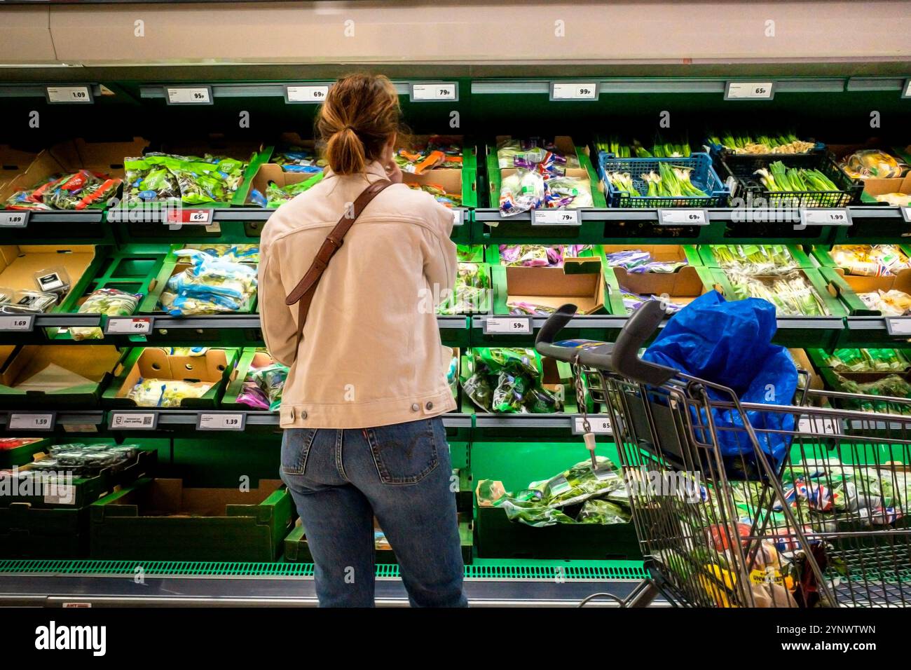 Un acheteur achetant des légumes frais dans un magasin Lidl en Angleterre au Royaume-Uni. Banque D'Images