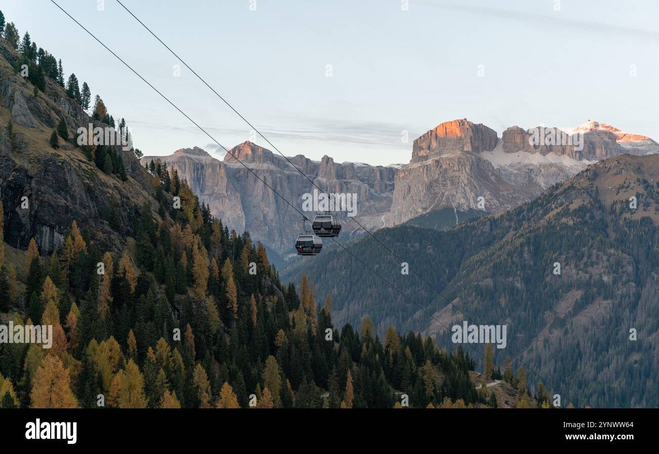Deux gondoles au-dessus d'un paysage d'automne au crépuscule, avec alpenglow sur les montagnes en arrière-plan Banque D'Images