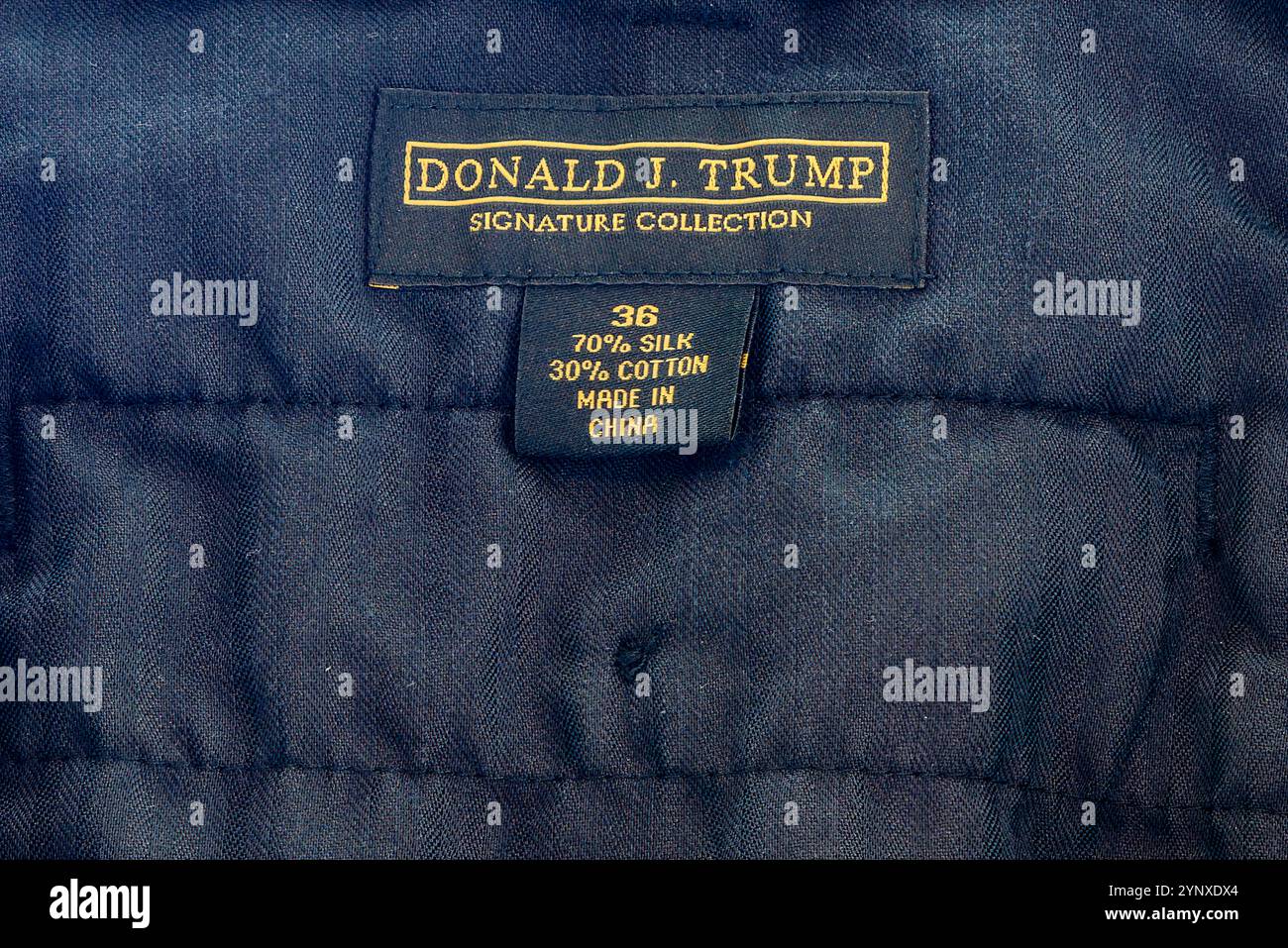 NOUVELLE-ORLÉANS, LOUISIANE, États-Unis - 27 SEPTEMBRE 2024 : gros plan de l'étiquette dorée à l'intérieur d'une paire de pantalons noirs qui indique « Donald J. Trump signature Collection » et la taille « 36 », « 70 % soie », « 30 % coton », « fabriqué en Chine » Banque D'Images