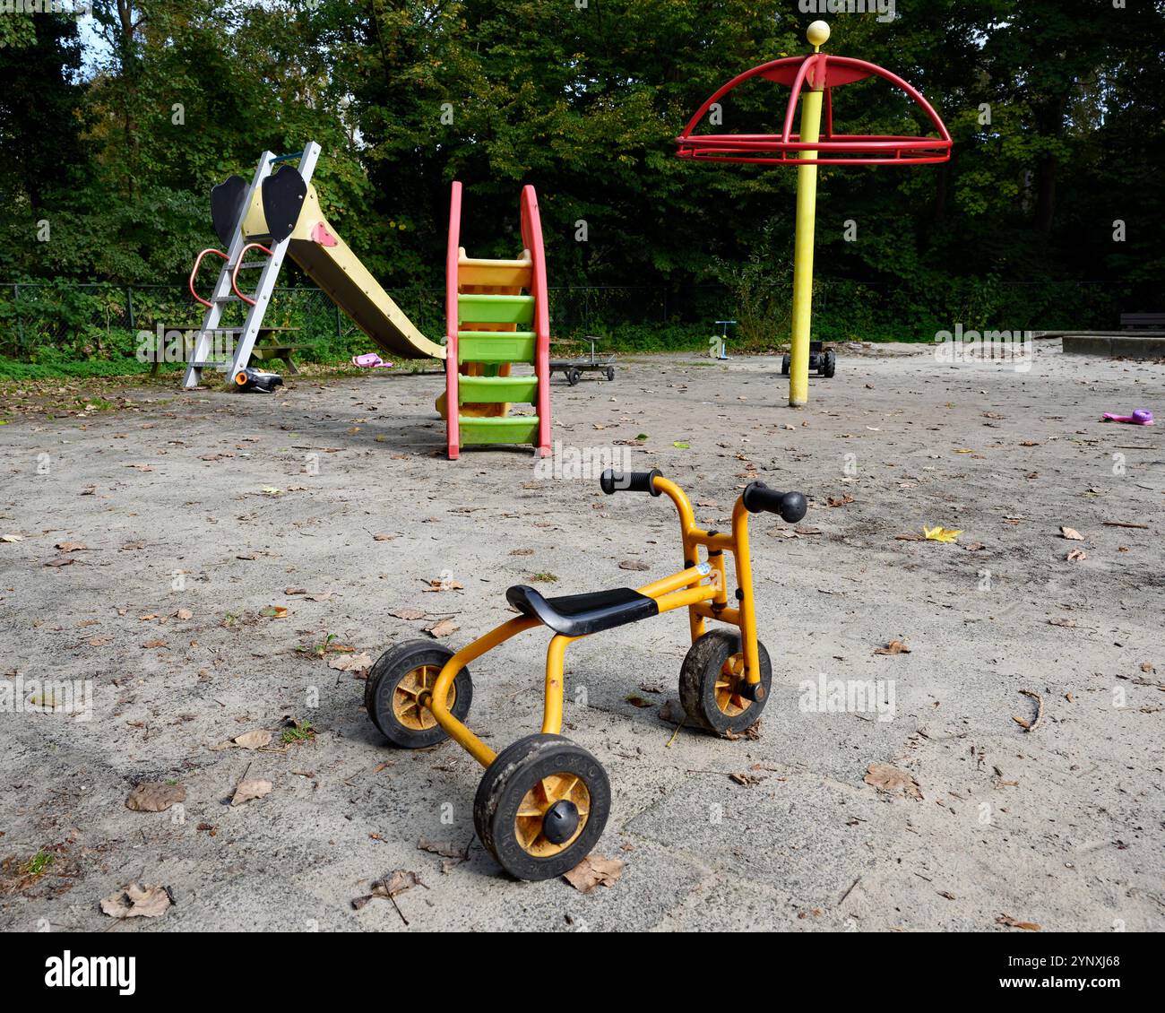 Aire de jeux déserte sans enfants ou personnes et jouets et tricycle apparemment abandonnés Banque D'Images