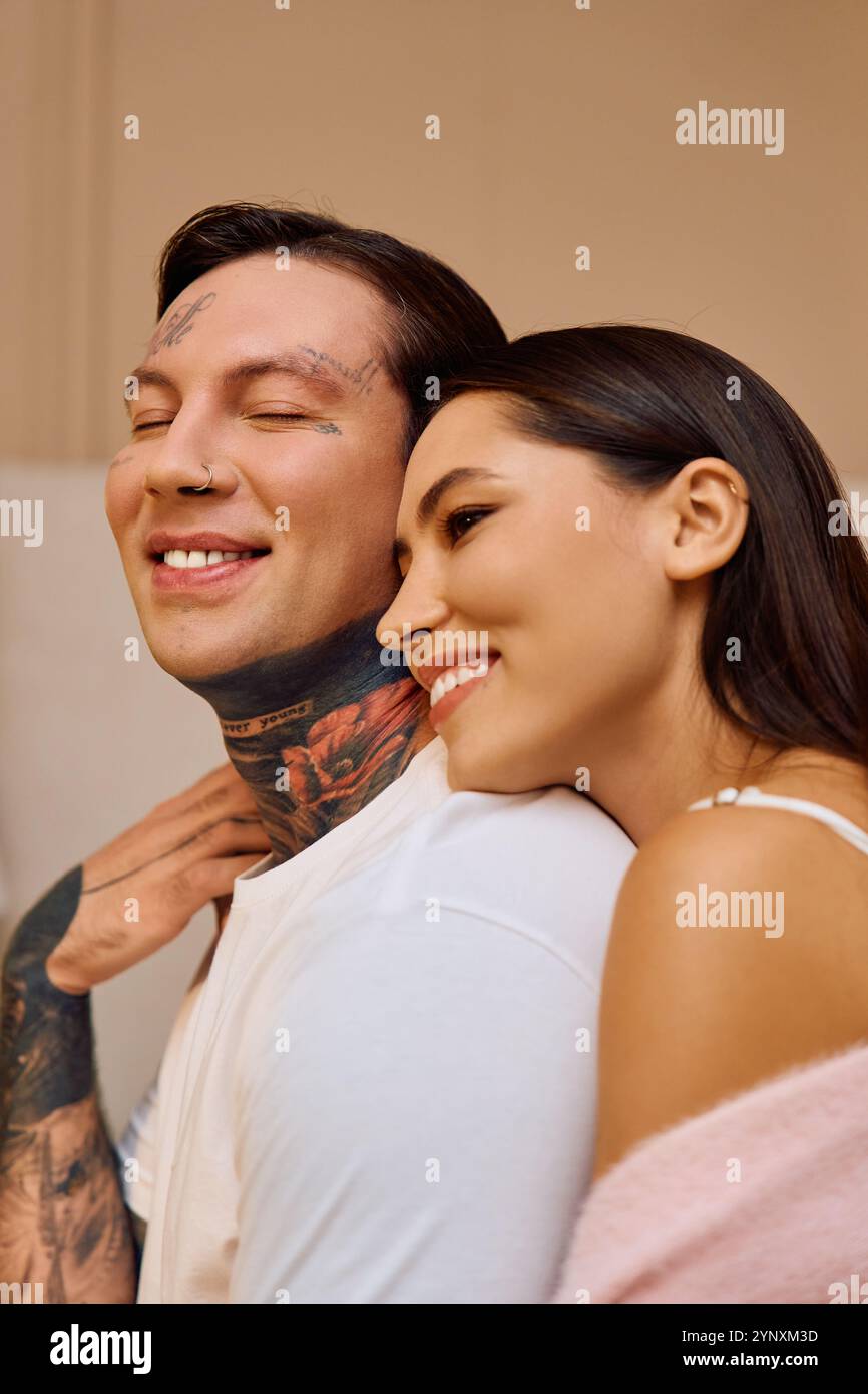 Joyeux couple embrasse tendrement, exprimant l'amour et la connexion dans un espace chaleureux et accueillant. Banque D'Images