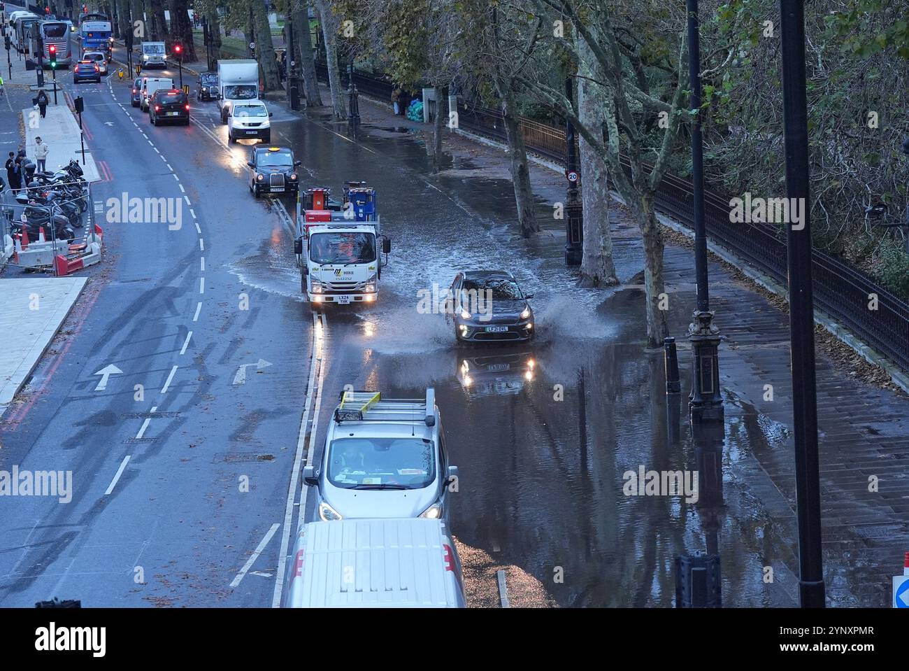 Les véhicules traversent les eaux de crue sur Victoria Embankment, dans le centre de Londres. Des trains ont été annulés dans certaines parties du sud de l'Angleterre après que de fortes pluies ont inondé les lignes de chemin de fer pendant la tempête Conall. Il arrive quelques jours seulement après que la tempête Bert a laissé des centaines de maisons inondées, transformé les routes en rivières et vu des vents de plus de 80 km/h. Date de la photo : mercredi 27 novembre 2024. Banque D'Images
