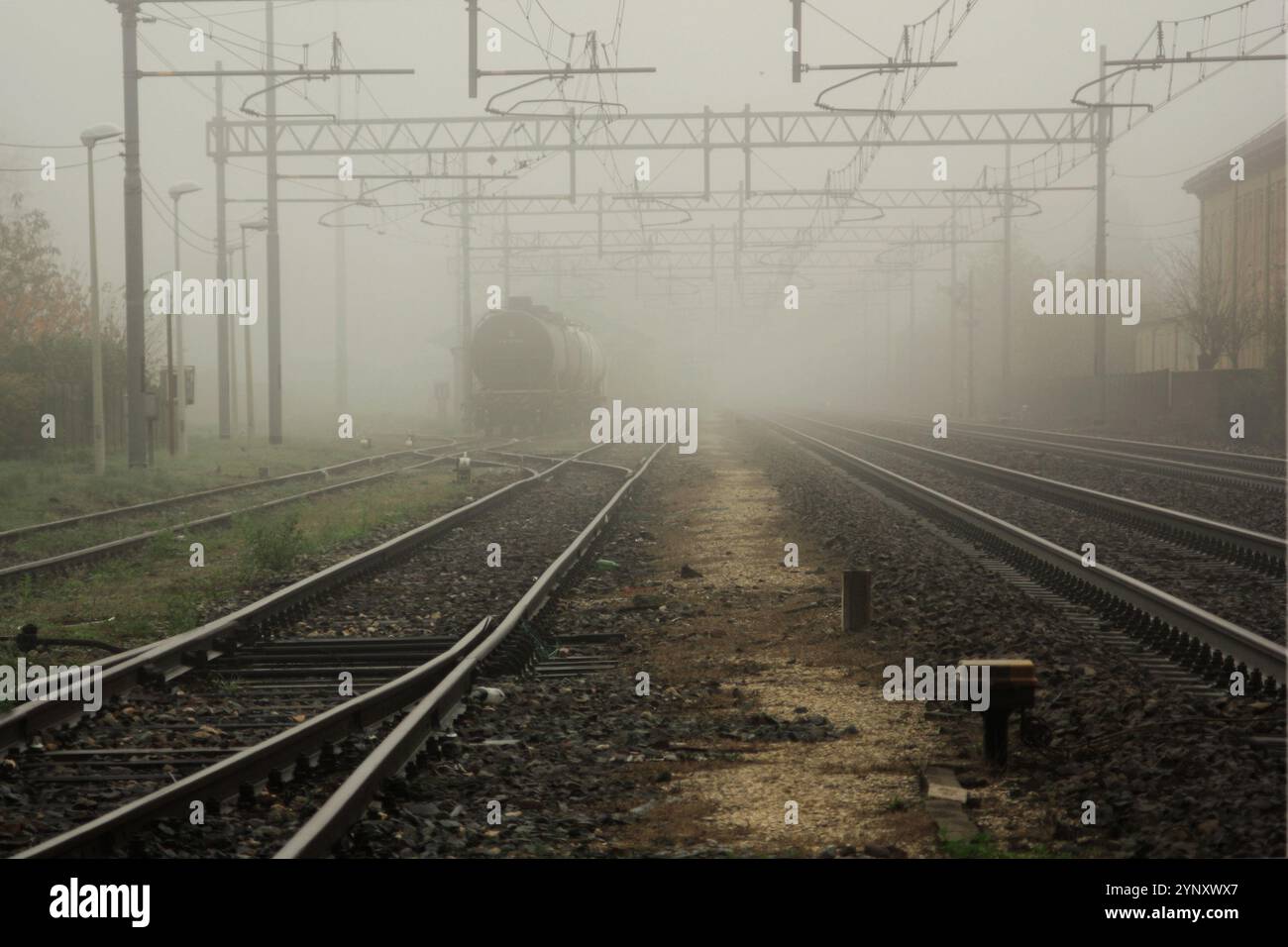 Train sur une voie ferrée dans la brume, Spinetta Marengo, Alessandria, Piémont, Italie Banque D'Images