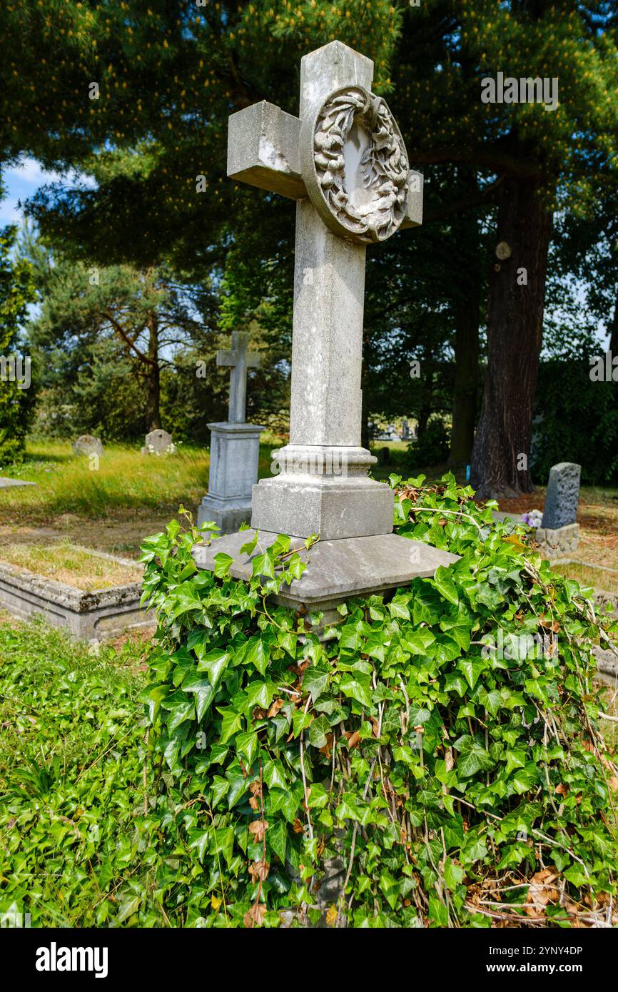 Vieille croix funéraire en pierre altérée avec couronne, cimetière historique à Gross Lassowitz, Powiat Kluczborski, Voïvodie d'Opole, Pologne. Banque D'Images