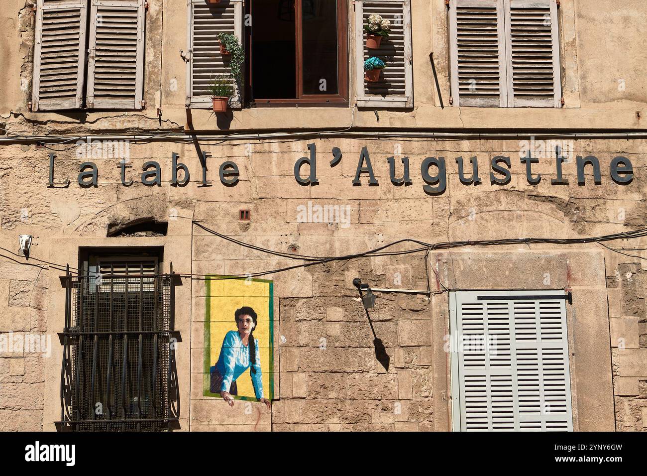 Marseille. France - 27 novembre 2024 : bâtiment rustique français avec fenêtres à volets et pots de fleurs, arborant le panneau « la table d'Augustine ». Perfe Banque D'Images