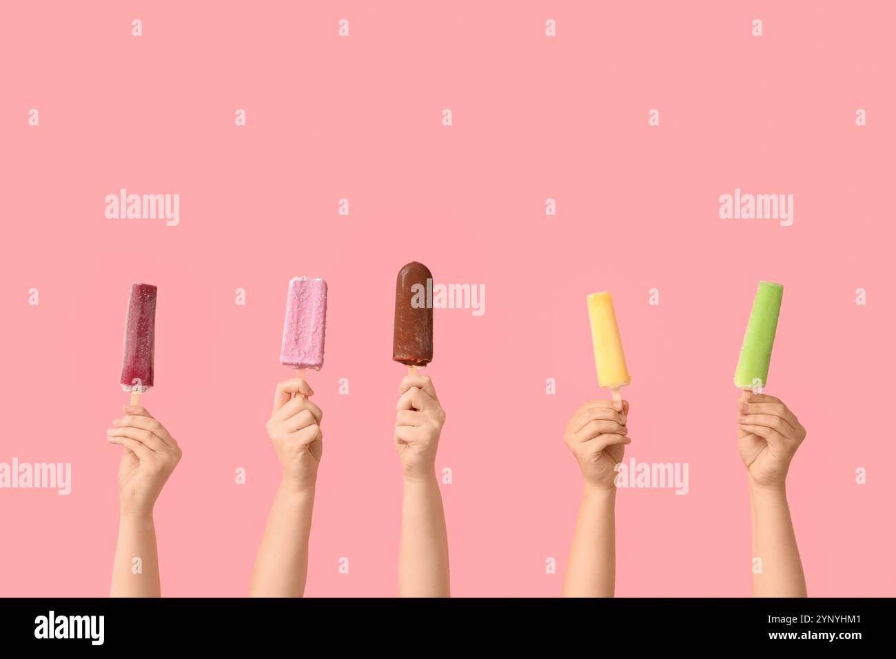 Mains féminines avec différentes glaces sucrées sur fond rose Banque D'Images