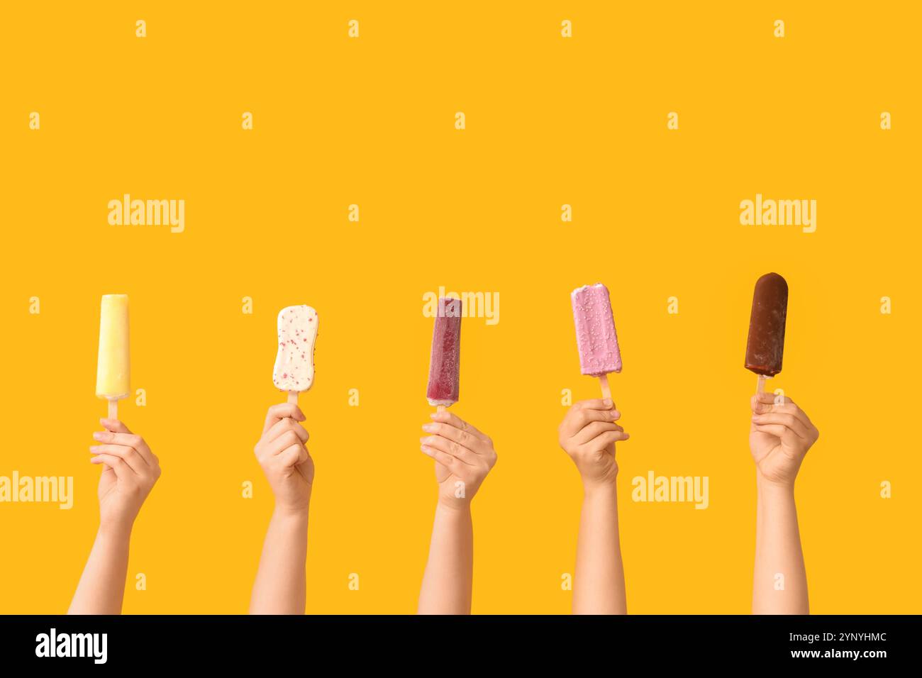 Mains féminines avec différentes glaces sucrées sur fond jaune Banque D'Images