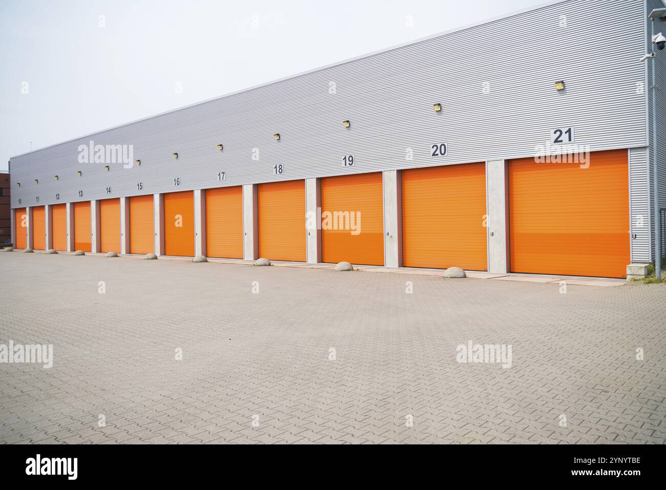 Extérieur d'un entrepôt commercial avec portes roulantes orange Banque D'Images