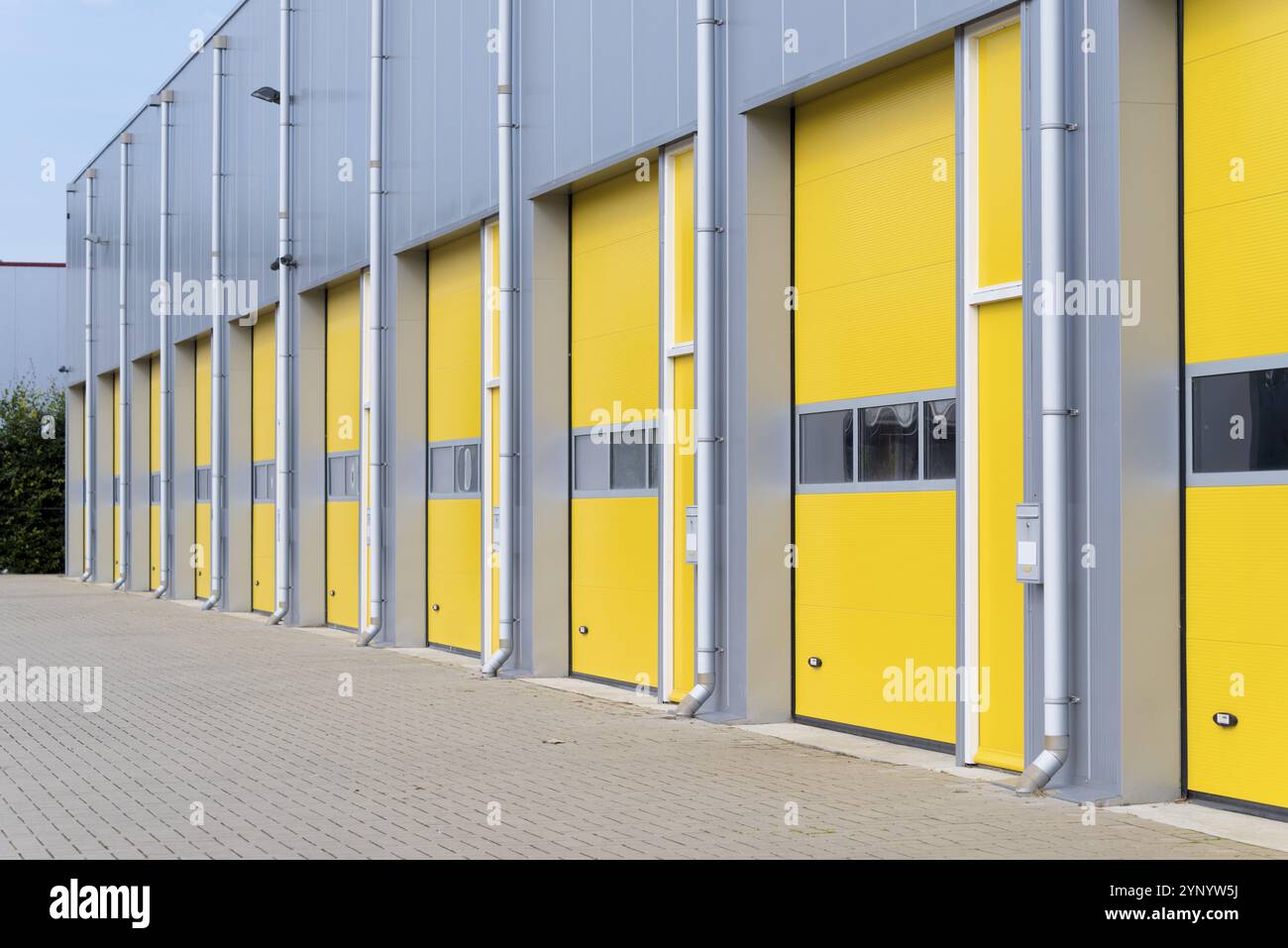 Extérieur d'un entrepôt commercial avec portes roulantes jaunes Banque D'Images